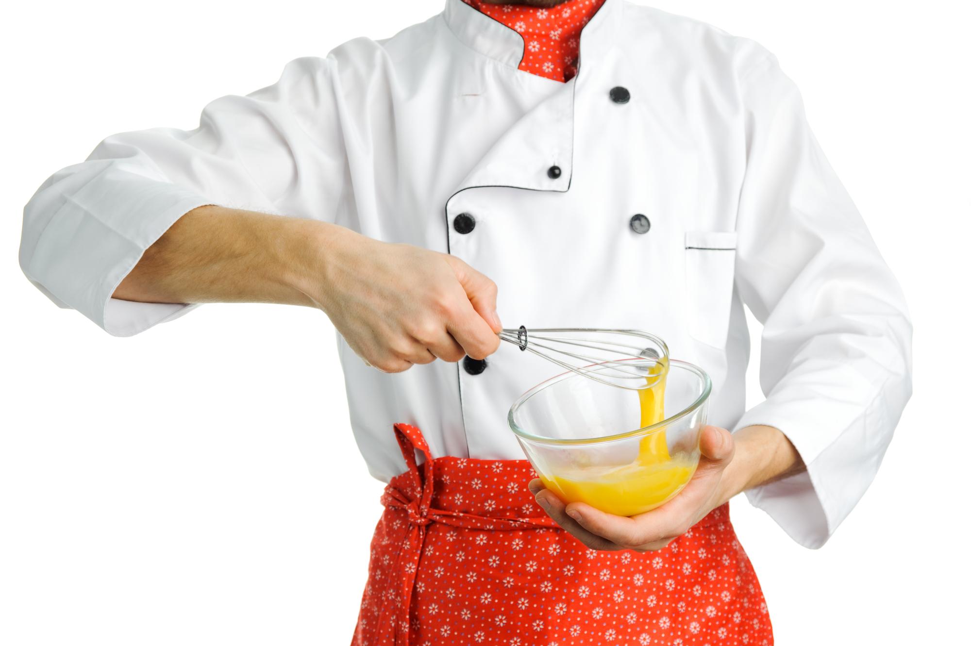 Chef che mostra una padella con sugo rosso